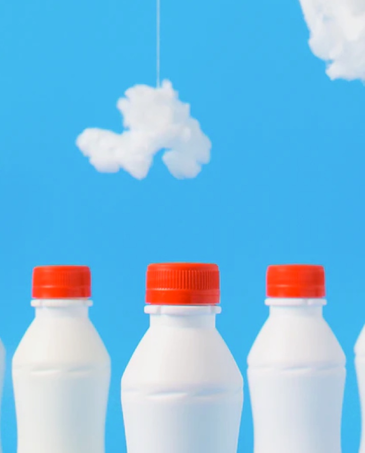 milk bottles lined up agfainst skyblue wall