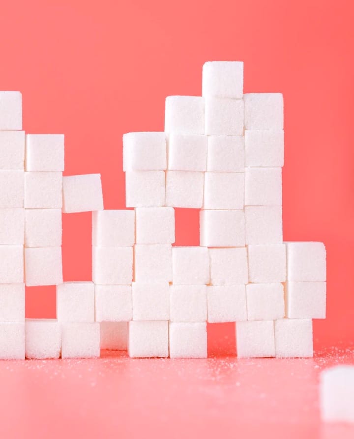 stacked sugar cubesagainst pink background